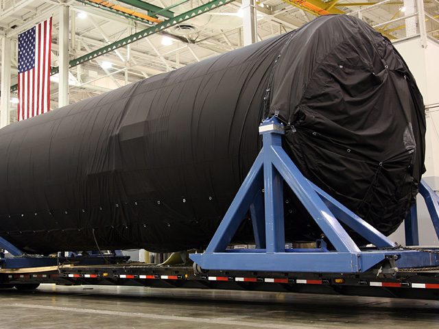 The Falcon 9 second stage and interstage, shrink-wrapped on a truck for the road.