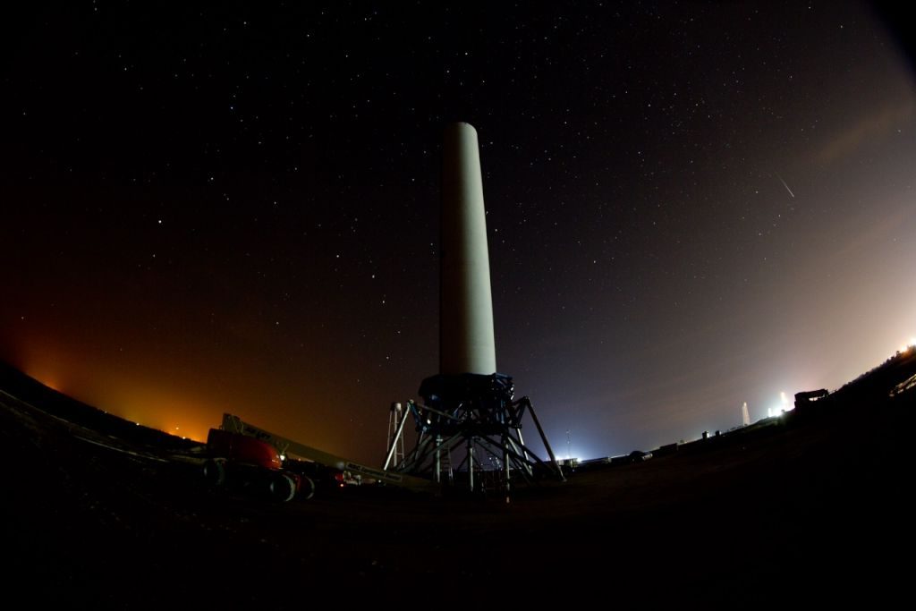 Grasshopper on its pad at night under a sky of stars, with a streak of light where Dragon crosses.